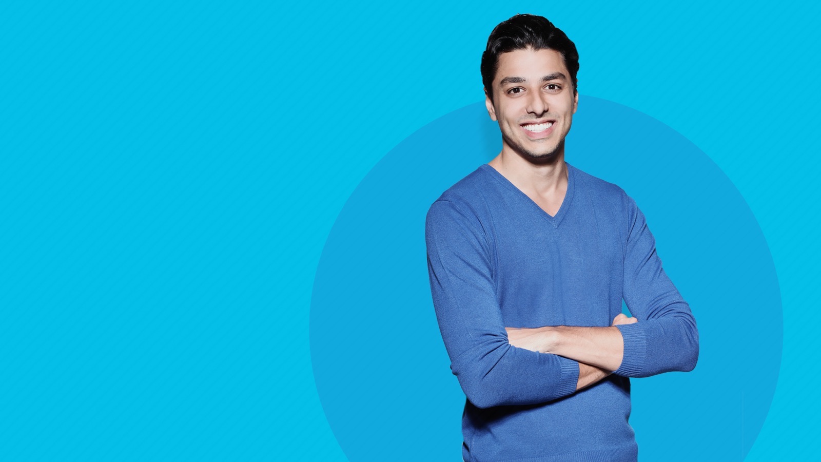 Gabriel Campaner sorrindo, braços cruzados, fundo azul